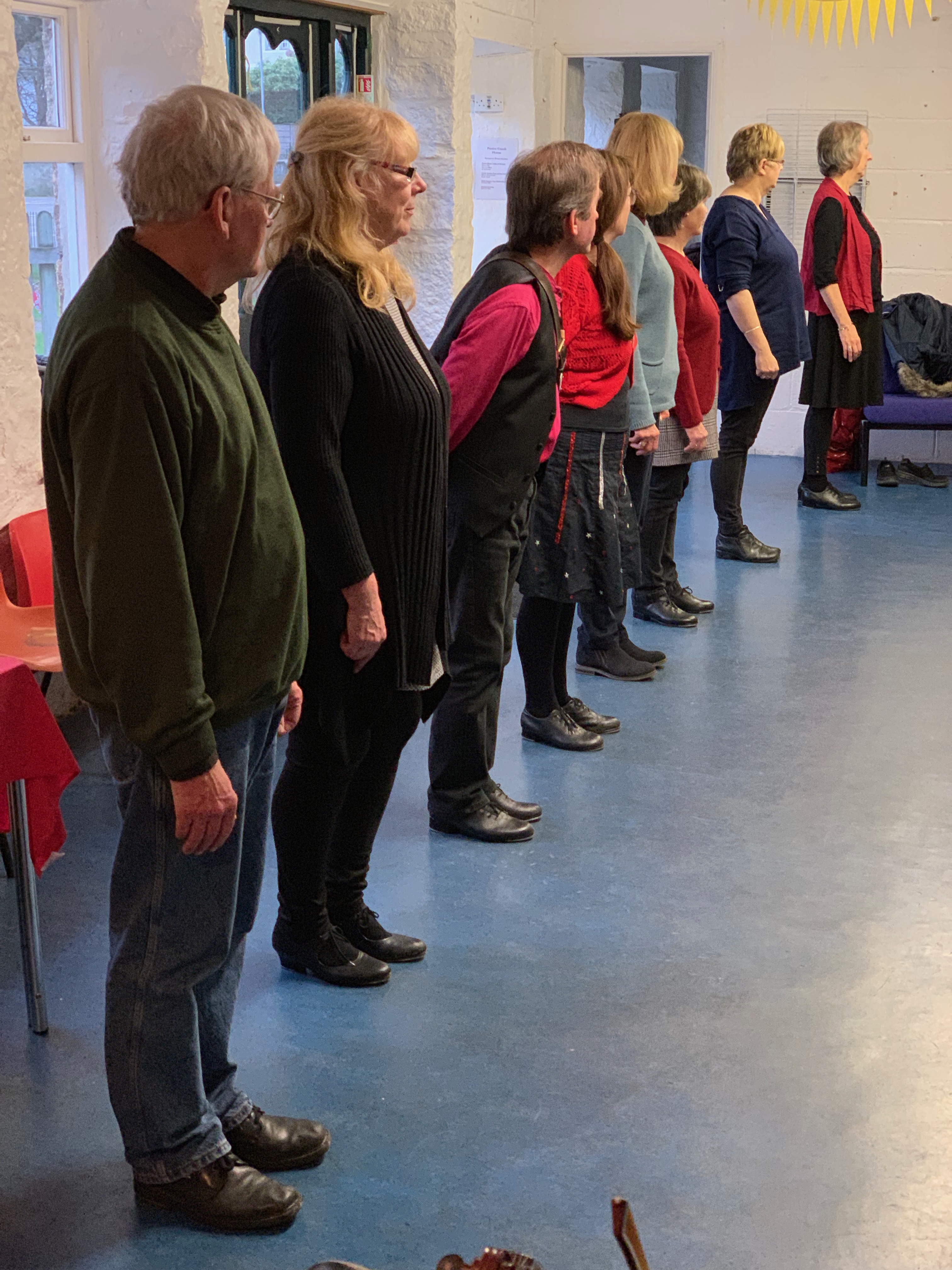 Photograph showing a line of beginners with Tros an Treys dancers at Penlee Coach House.